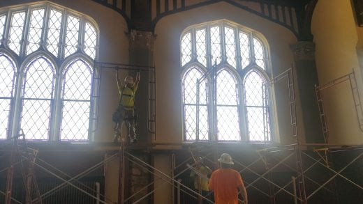 A Belfor worker builds scaffolding in front of the Ornamental windows in the Great Room.