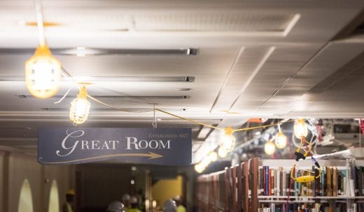 Near a Great Room sign on Hale Library's third floor, yellow construction lights are strung across the ceiling.