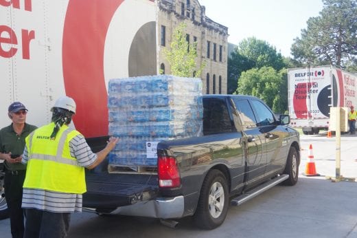 A pallet of bottled water sits in the back of a black truck.