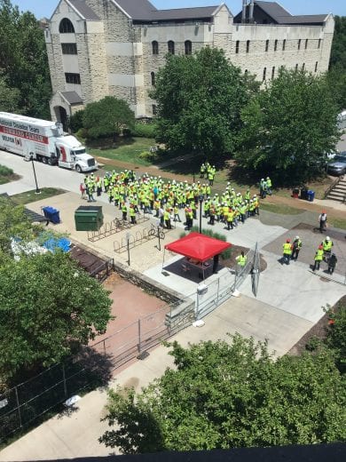 A group of people gather around each other in Yellow vests. 