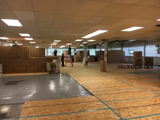 Inside Ag Press building with plywood floors and boxes of books.