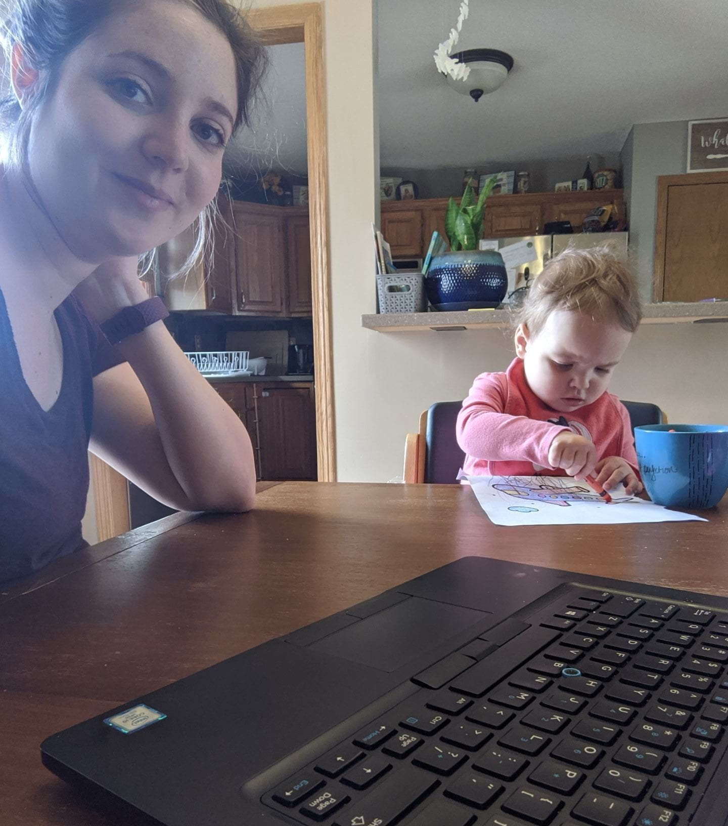 Stephanie working from home, with her toddler playing nearby.