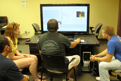 4 students using a new 46-inch screen in the MDC