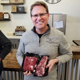 Man holding packaged cuts of Wagyu beef