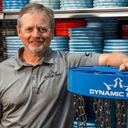 Man standing in front of shelf filled with discs