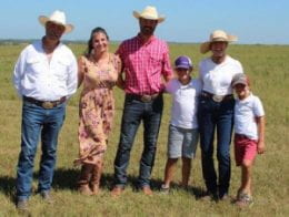 Family of six standing in farm field