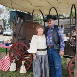 Woman and man standing in front of chuckwagon