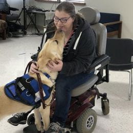 Corwin, an assistance dog, with girl in a wheelchair