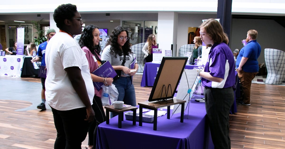 Visitors talk with a student ambassador at a tabling event at the Student Union.