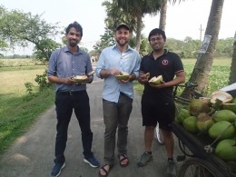 Aaron Shew (middle) and his research colleagues take a break from their work to enjoy a coconut